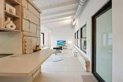 a kitchen with a stone wall and a large window at Coconut Grove Mid-Century Jungle Oasis in Miami