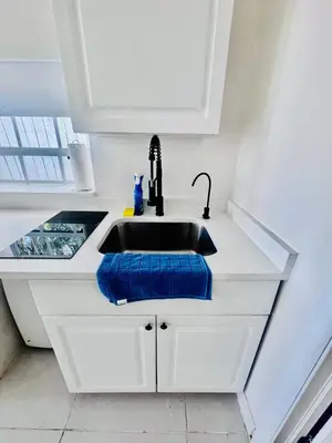a kitchen sink with a blue towel next to it at Modern Home - Termpurpedic Queen bed, Laundry, Free Parkging, EV Tesla in Hollywood
