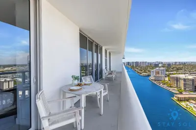 a balcony with a table and a view of the water at Bayview Luxury: 3BR Pools Oceanfront Amenities in Hollywood