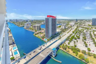 an aerial view of a city with a river and a bridge at Bayview Luxury: 3BR Pools Oceanfront Amenities in Hollywood