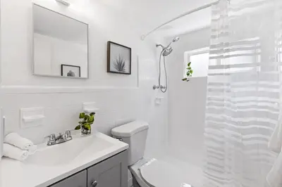 a white bathroom with a sink and a shower at Lovely Studio with Great Location + Free Parking in Fort Lauderdale