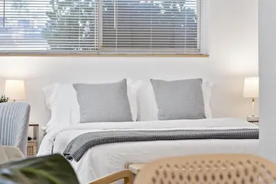 a bedroom with a bed with a window and a chair at Lovely Studio with Great Location + Free Parking in Fort Lauderdale