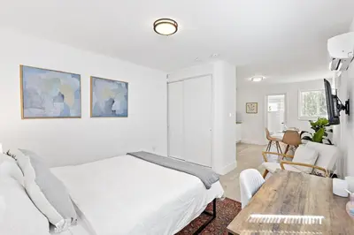 a white bedroom with a bed and a table at Lovely Studio with Great Location + Free Parking in Fort Lauderdale