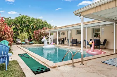 a swimming pool with inflatable swans in a backyard at Villa Oasis 3 Miles to Hard Rock Stadium & Casino, Guitar Hotel Nearby, Pool, Game Room, Sleeps 12, 15 Min to Beach in Pembroke Pines