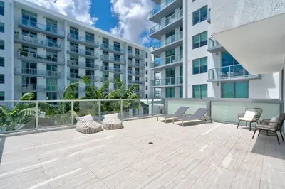 an apartment patio with chairs and a large building at 3900-719JC DESIGN DISTRICT, CONDO 1 BEDROOM /1 BATHROOM & BAYVIE in Miami