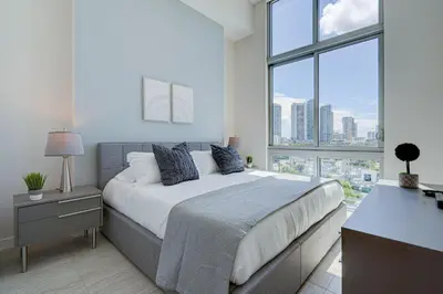 a bedroom with a bed and a large window at 3900-502GJ DESIGN DISTRICT, CONDO 2 BEDROOMS & 2 BATHROOMS in Miami
