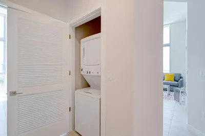 a white refrigerator freezer sitting inside of a kitchen at 3900-502GJ DESIGN DISTRICT, CONDO 2 BEDROOMS & 2 BATHROOMS in Miami
