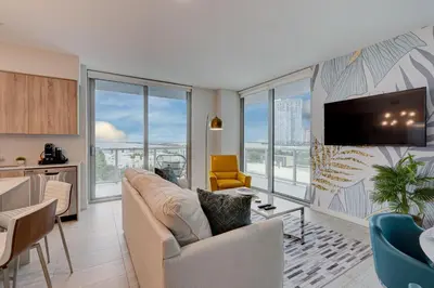 a living room with a couch and a tv at 3900-717AS DESIGN DISTRICT, CONDO 2 BEDROOMS & 2 BATHROOMS & BAY in Miami