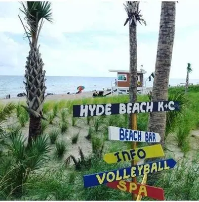 a beach with signs and palm trees and the ocean at Sian Oceanfront Condos in Hollywood