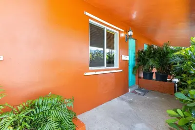 an orange house with plants and a window at The Perfect Escape @Lake Ridge in Fort Lauderdale