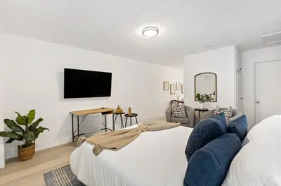 a bedroom with a white bed and a blue couch at Charming cozy studio @ Lake Ridge in Fort Lauderdale