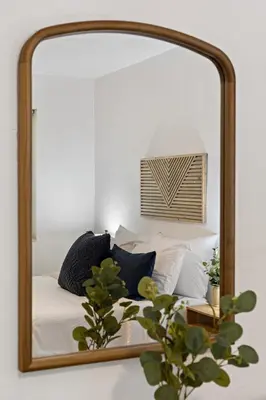 a mirror reflecting a bed with pillows at Charming cozy studio @ Lake Ridge in Fort Lauderdale