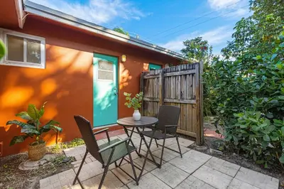 a patio with a table and chairs in front of a house at Charming cozy studio @ Lake Ridge in Fort Lauderdale