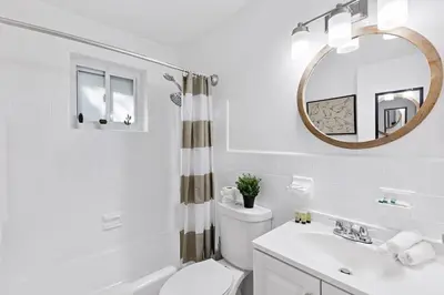 a bathroom with a toilet and a sink and a mirror at Lake Ridge Villa - Free Parking in Fort Lauderdale