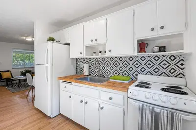 a kitchen with white cabinets and a white refrigerator at Lake Ridge Villa - Free Parking in Fort Lauderdale