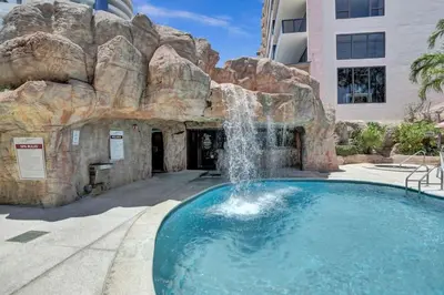 a swimming pool with a waterfall in front of a building at High floor Oceanview condo 1506 in Miami Beach