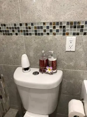 a bathroom with a toilet with two candles on it at Modern apartment steps the beach in Miami Beach