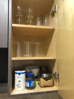 a cupboard with jars and other kitchen items in it at Modern apartment steps the beach in Miami Beach
