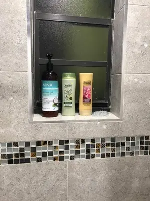 three bottles of soap sitting on a shelf in a bathroom at Modern apartment steps the beach in Miami Beach