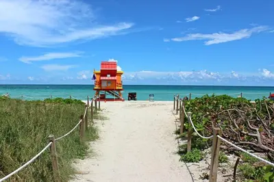 a path leading to a beach with a lifeguard house at Modern apartment steps the beach in Miami Beach