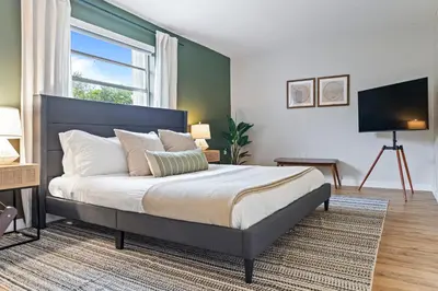 a bedroom with a large bed and a window at Hidden Garden: A Serene Miami Escape in Cutler Bay
