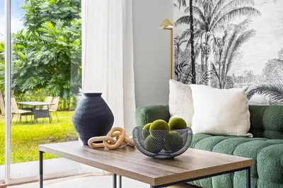 a living room with a green couch and a table at Hidden Garden: A Serene Miami Escape in Cutler Bay