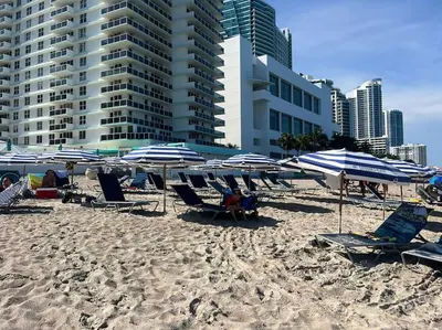 a group of chairs and umbrellas on a beach at Bright Miami Beach Stay with Amazing Views, Full Kitchen -A in Hallandale Beach