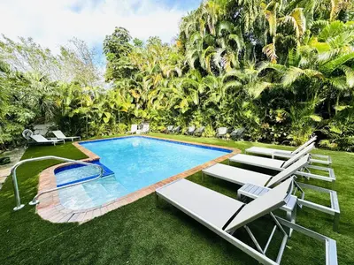 an image of a swimming pool in a yard with lounge chairs at Progresso Apartments & Homes by Lowkl in Fort Lauderdale