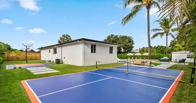 a tennis court in front of a house at New Spectacular 6BR Bliss - Pool - Spa & Pickell in Miami