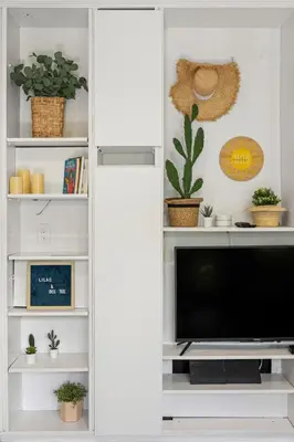 a living room with a tv in a white cabinet at Delight and cozy Apt close to Las Olas & the beach in Fort Lauderdale
