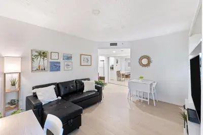 a living room with a black couch and a table at Welcoming Airbnb Walkig distance to Las Olas Blvd in Fort Lauderdale