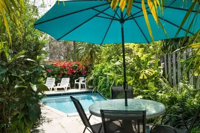 a table with an umbrella next to a pool at Bright and Stylish Apt in Las Olas Blvd Victoria Park in Fort Lauderdale