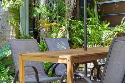 a wooden table and chairs in a patio with plants at Bright and Stylish Apt in Las Olas Blvd Victoria Park in Fort Lauderdale