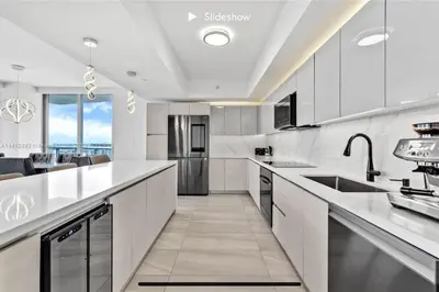 a kitchen with white appliances and a large window at Apartment 3B/3B Bay View in Hallandale Beach