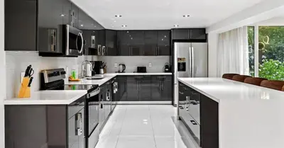 a kitchen with black cabinets and white counter tops at Miami's Exclusive Lagoon Villa in Miami