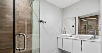 a bathroom with two sinks and a glass shower at Miami's Exclusive Lagoon Villa in Miami