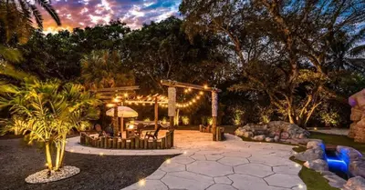 a patio with a table and chairs and lights at Miami's Exclusive Lagoon Villa in Miami