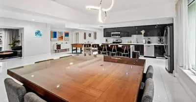 a large dining room and kitchen with a large wooden table at Miami's Exclusive Lagoon Villa in Miami