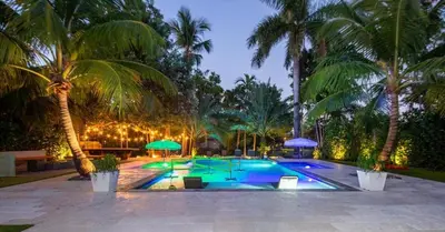 a swimming pool with palm trees in a resort at New Oasis Waterfront & Sand Terrace THG in Miami