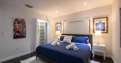 a bedroom with a blue bed with two pillows on it at New Oasis Waterfront & Sand Terrace THG in Miami