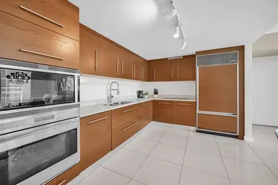 a kitchen with wooden cabinets and a stainless steel appliance at Water & Pool Views, One bedroom W hotel building in Miami