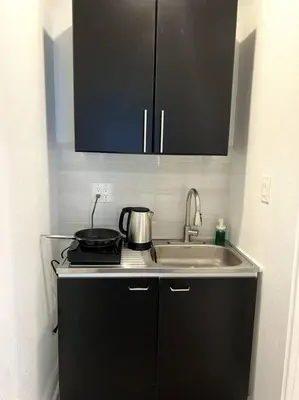 a kitchen with a sink and a pot on a stove at Nice and Cozy guest house in Miami