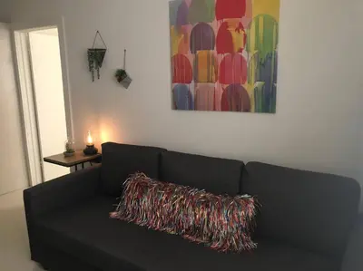 a black couch with a colorful pillow on it in a living room at BEAUTIFUL APARTMENT FOOTSTEPS FROM THE BEACH in Miami Beach