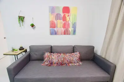 a gray couch with a pillow on it in a room at BEAUTIFUL APARTMENT FOOTSTEPS FROM THE BEACH in Miami Beach
