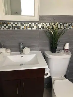 a bathroom with a sink and a toilet and a plant at MODERN AND ECLECTIC APARMENT A STEPS THE BEACH in Miami Beach