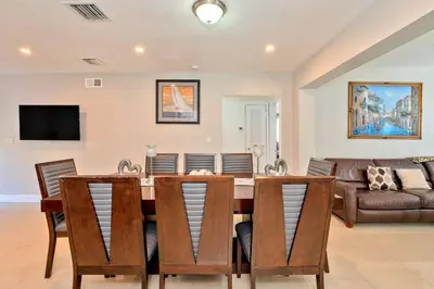 a dining room with a table and chairs and a couch at Luxurious 5 bedrooms Jacuzzipool in Miramar