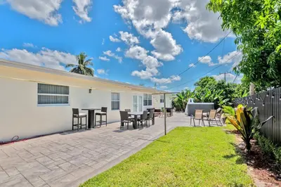 a patio with chairs and tables in a backyard at Luxurious 5 bedrooms Jacuzzipool in Miramar
