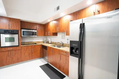 a kitchen with wooden cabinets and a refrigerator at SIAN private Apartments in Hollywood