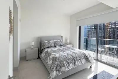 a white bedroom with a bed and a large window at New 1/1 Apartment in Smart Brickell with Parking in Miami