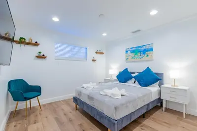 a bedroom with a bed and a blue chair at Lakefront Villa and Paddle Board TGH in Miami